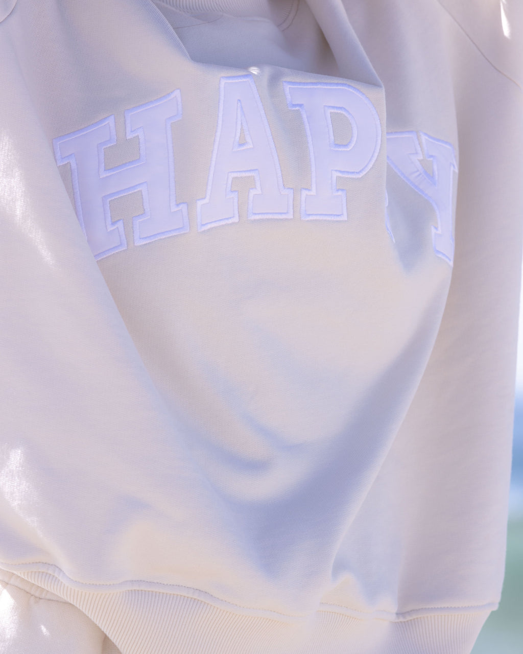 Off white mockneck sweatshirt with white 'HAPPY' text.