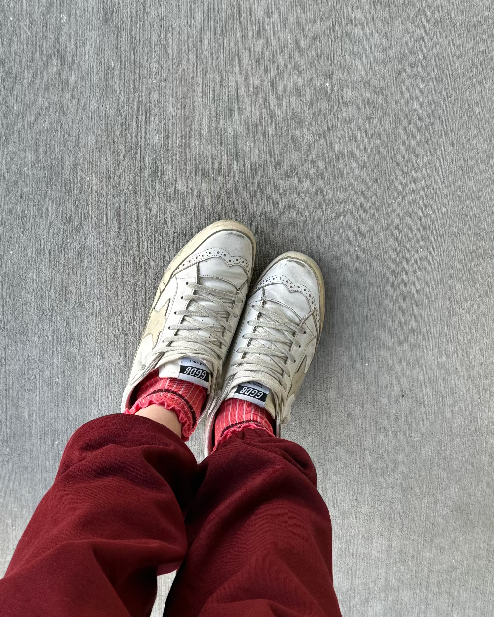 golden goose sneakers with red and pink ruffle socks and red jogger sweatpants